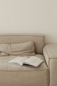 Kaboompics - Open Book on Beige Sofa with Minimalist Living Room Copy Space