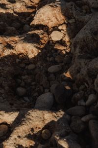Kaboompics - Rounded Pebbles Tucked into a Shadowed Rock Crevice