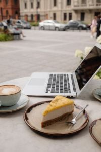 Kaboompics - Laptop and Cheesecake with Coffee in an Outdoor Cafe