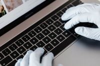 Kaboompics - Close-Up of Hands in Protective Gloves Typing on Laptop Keyboard