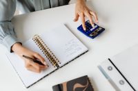 Kaboompics - Close-Up of Hand Writing Notes Beside a Calculator