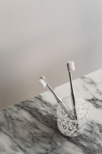 Kaboompics - Toothbrushes in Glass Close-Up on Arabescato Marble