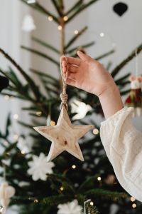 Kaboompics - Hands Holding Wooden Star Ornament on Christmas Tree