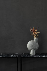 Kaboompics - Centered Sculptural Gray Vase with Dried Flower on a Black Marble Shelf