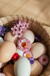 Kaboompics - Pink Spring Blossoms and Pastel Eggs in a Wicker Basket for Easter Content