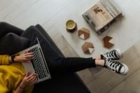 Kaboompics - Overhead View of Woman Typing on Laptop from Sofa, Cozy Remote Work at Home