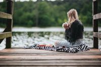 Kaboompics - Blonde woman having a healthy snack at the wooden pier
