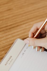 Kaboompics - Hand Writing in Notebook With Wooden Desk Copy Space