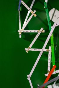 Extandable wooden ruler on a green background