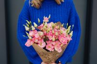 Kaboompics - Close up of woman holding bouquet of pink lisianthus flowers wrapped in brown paper