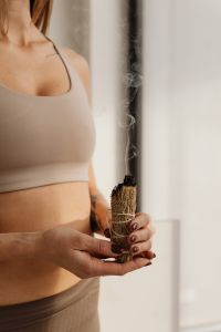 Kaboompics - Woman Holding Smoldering Sage Against a Bright Background