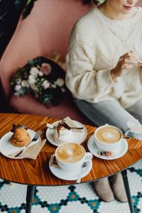 Kaboompics - Coffee and Pastries on a Wooden Cafe Table beside a Pink Bouquet