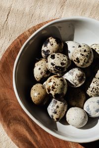 Kaboompics - Close-Up of Speckled Eggs in a Dark Ceramic Bowl, Moody Spring Food Photography