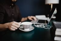 Kaboompics - Cappuccino Break at Home Office Desk with Laptop, Stacked Books and Table Lamp