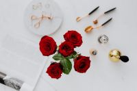 Kaboompics - Red roses, gold rings, perfume brushes and make-up accessories on white marble