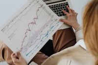Kaboompics - Overhead View of Businesswoman Holding Financial Charts beside a Laptop