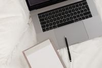 Kaboompics - Laptop Keyboard with Blank Notebook and Pen on White Bedding