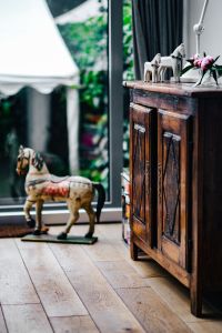Kaboompics - Vintage Wooden Cabinet with Horse Sculptures and Flowers
