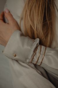 Kaboompics - Gold Bracelets on Tan Silk Shirt Cuff