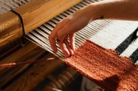 Kaboompics - Hand Guiding Yarn Through a Wooden Loom