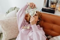 Kaboompics - Woman Holding Dollar Bills Over Her Face on a Sofa