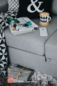 Kaboompics - Coffee Break Still Life with Magazines and Smartphone on Gray Sofa