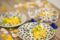 Kaboompics - Yellow rice with greens on a cute plate with blue hearts and a table decorated with flower petals