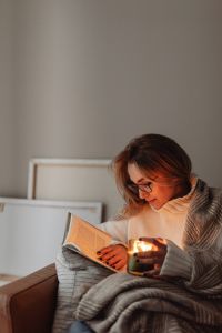 Kaboompics - Woman in Glasses Reading by Candlelight at Home