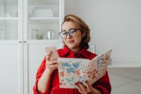 Kaboompics - Woman Checking Smartphone and Reading Design Magazine at Home Office