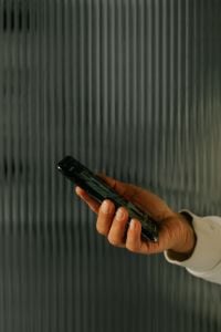 Kaboompics - Hand Holding Smartphone With Glass Doors in Background