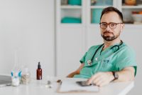 Doctor Seated With Stethoscope in Consultation Room