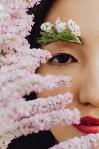 Kaboompics - Asian Woman Portrait with Floral Eyebrow Makeup Framed by Pink Blossoms