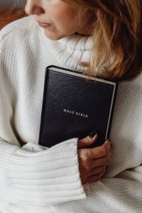 Kaboompics - Woman Clutching a Holy Bible in a White Knit Sweater