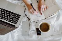 Kaboompics - Woman working on a laptop while enjoying a breakfast coffee and chocolate in bed