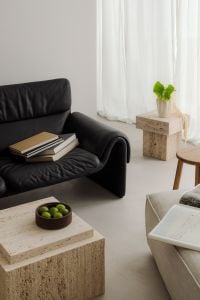 Kaboompics - Japandi Living Room with Black Leather Sofa and Travertine Tables