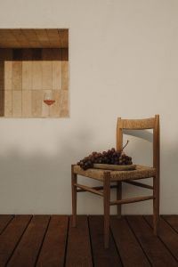 Kaboompics - Red Grapes on Woven Chair beside Wall Shelf