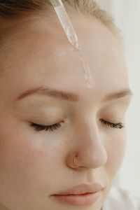 Kaboompics - Applying Facial Serum Dropper to the Forehead During Skincare