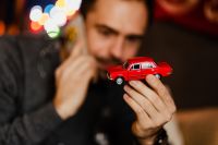 Kaboompics - Blurred Man Holding Red Toy Car during Phone Call