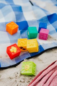 Kaboompics - Colorful Toy Blocks on a Blue Gingham Beach Blanket for Kids' Summer Activities