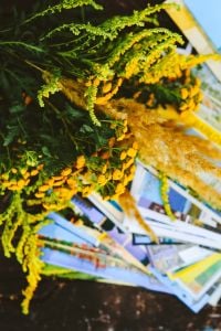 Yellow flowers with miscellaneous items on wooden floor