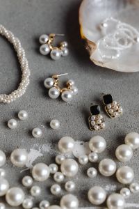 Kaboompics - Pearl Necklace and Mixed Gold-and-Pearl Earrings on Gray Concrete, Vertical Flat Lay