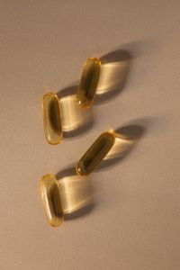 Kaboompics - Golden Supplement Capsules with Long Shadows