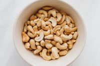 Kaboompics - Close-Up of Cashew Nuts in a White Ceramic Bowl for Healthy Snack Packaging