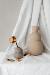 Kaboompics - Dried Rose and Sculptural Beige Vases on Draped White Linen