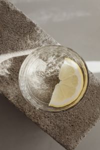 Kaboompics - Close-Up of Lemon Water Glass on Textured Stone Block