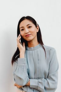 Kaboompics - Smiling Asian Woman Talking on a Smartphone in Close-Up
