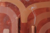 Kaboompics - Close-Up of Smoking Taper Candles Against Terracotta Abstract Art