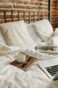 Kaboompics - Coffee, Watch and Laptop on Unmade Bed with Brick Wall Background