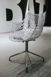 Kaboompics - Transparent Grid-Back Chair Against Oversized Black-and-White Exhibition Typography