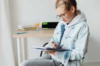 Kaboompics - Girl Doing Homework in Notebook at Home